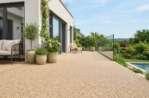 Terrasse en moquette de pierre beige devant une baie vitrée